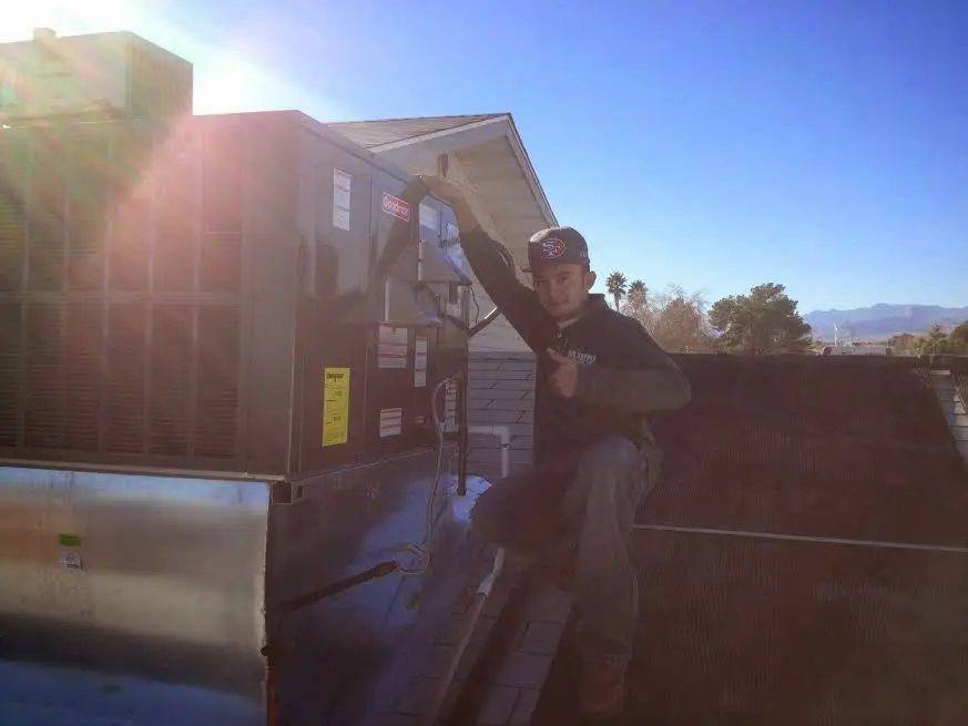 HVAC technician performing AC Tune-Up on a rooftop unit in Leavenworth